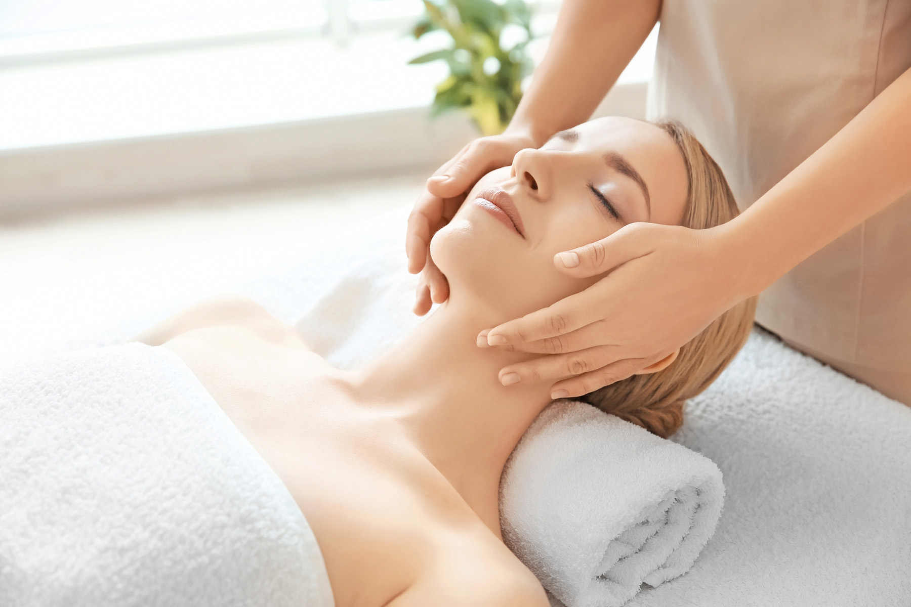 Young woman enjoying of facial massage in spa salon Young woman enjoying of facial massage in spa salon